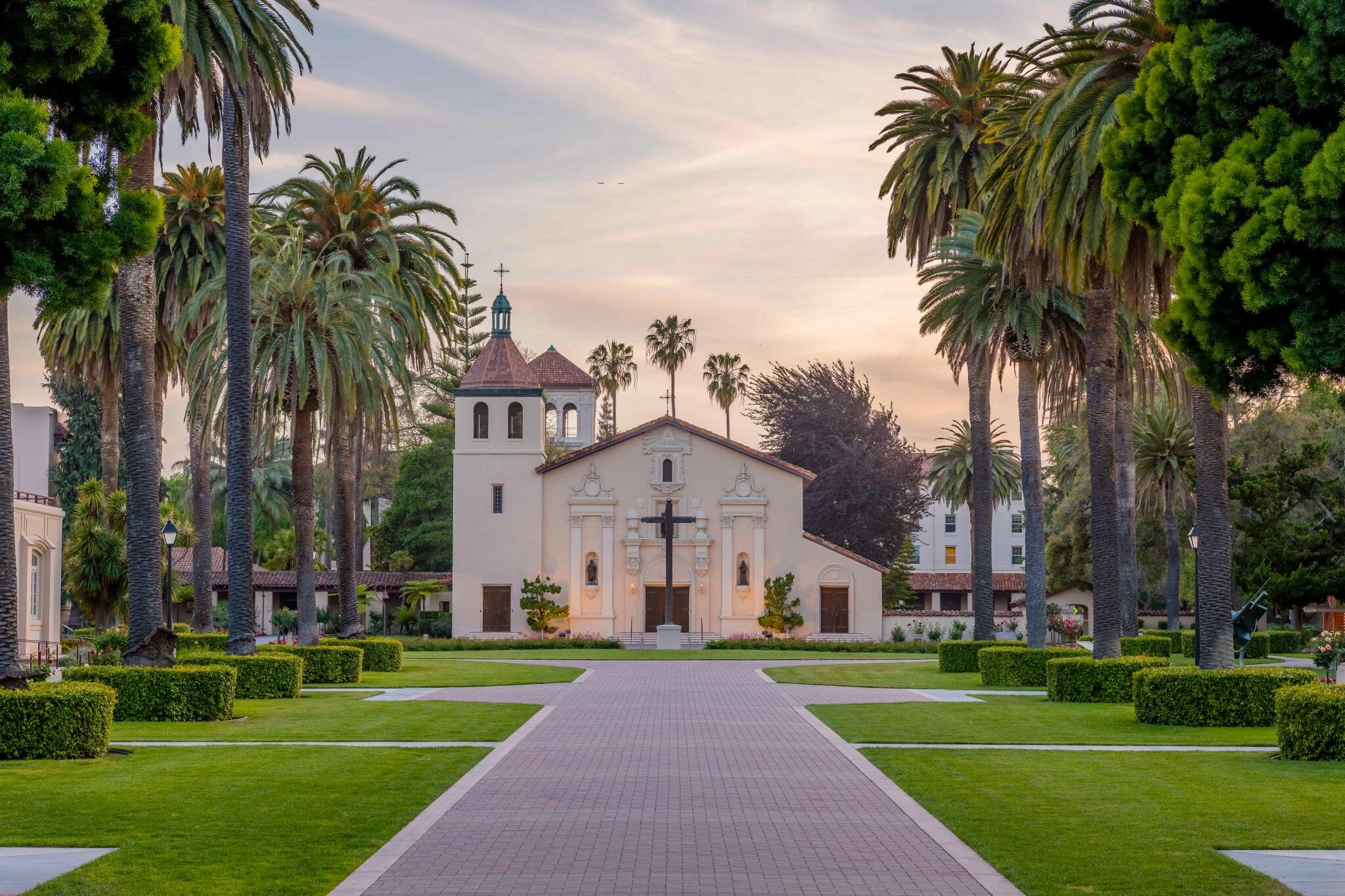 Mission Santa Clara de As&iacute;s at dusk, framed by palm trees